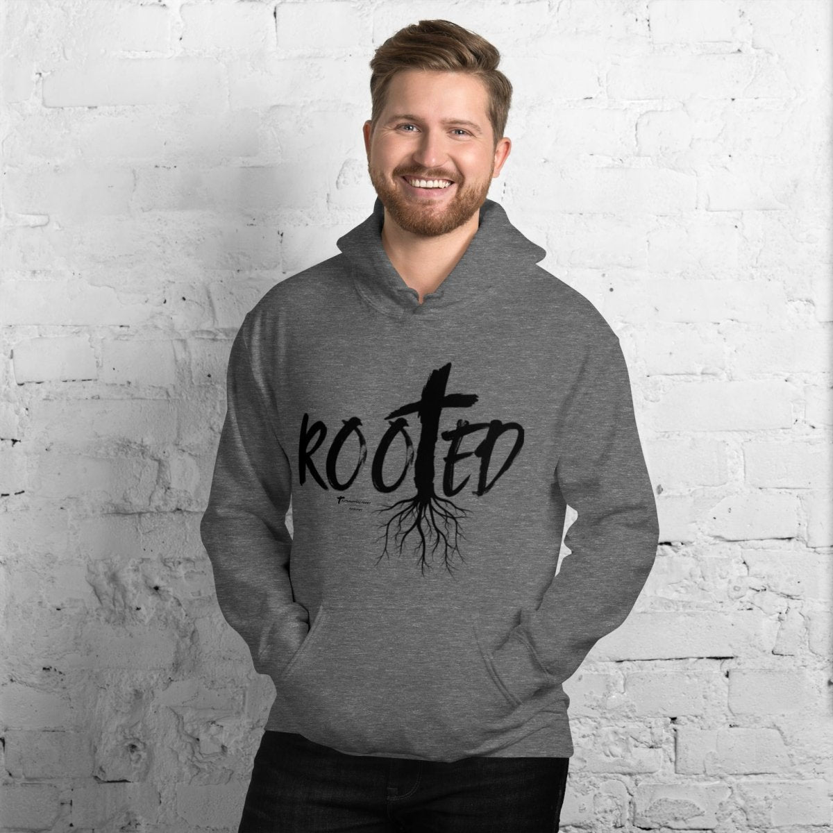 Front view of Truth Matters’ Rooted in Christ Hoodie with a cross and tree roots in ‘ROOTED’ in soft heather grey.
