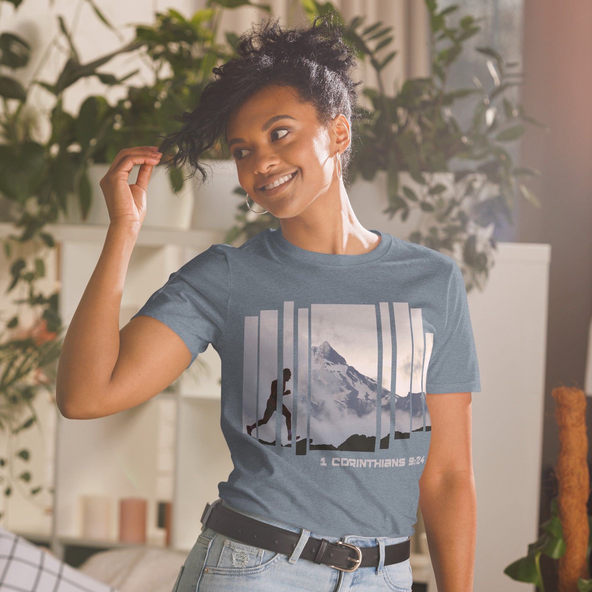Woman wearing Truth Matters Run the Race 1 Corinthians 9:24 t-shirt in Heather Indigo, front runner and mountain graphic