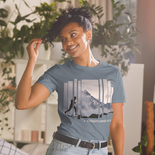 Woman wearing Truth Matters Run the Race 1 Corinthians 9:24 t-shirt in Heather Indigo, front runner and mountain graphic