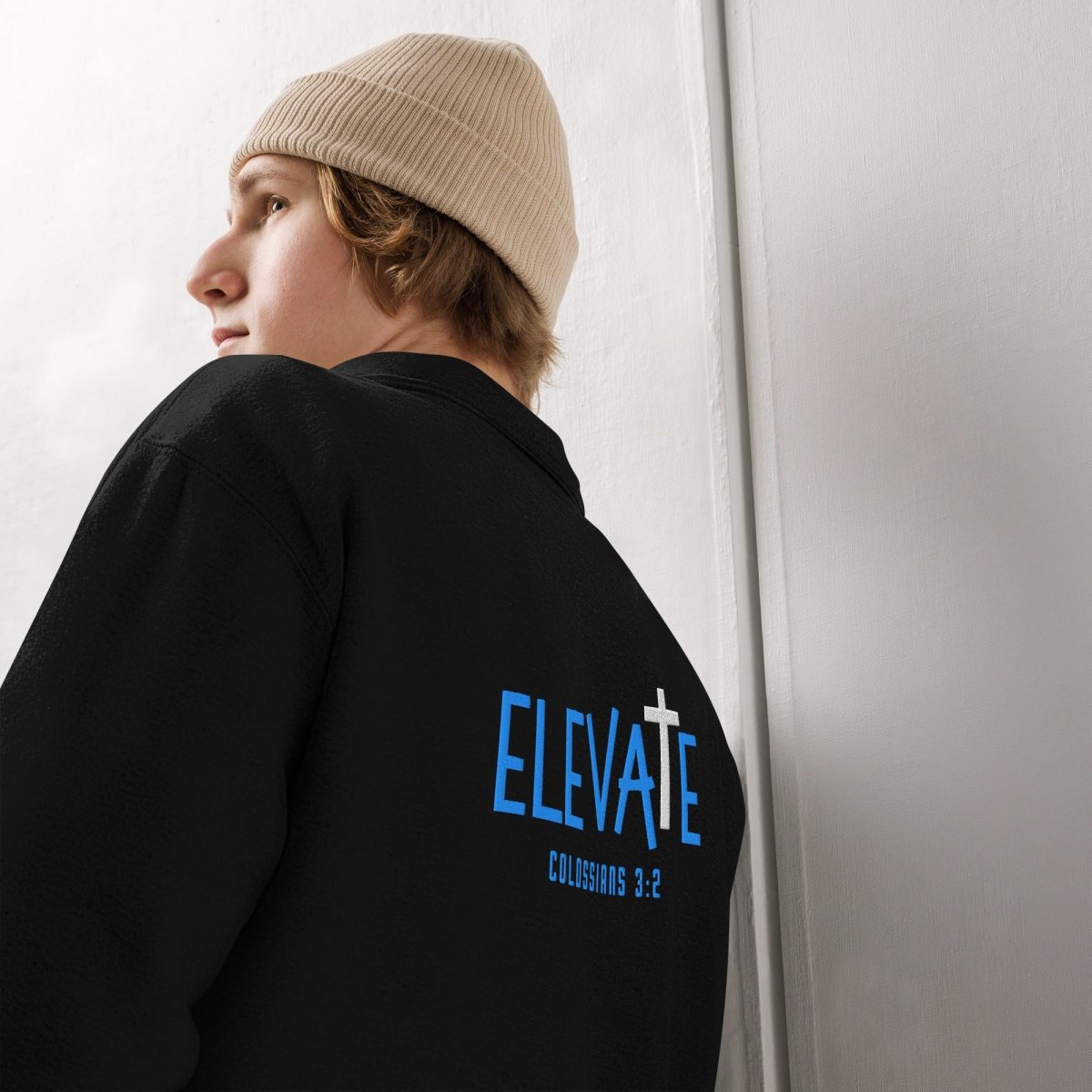 Close-up of premium embroidery on Elevate Christian quarter-zip showing ELEVATE with elevated cross T and Colossians 3:2